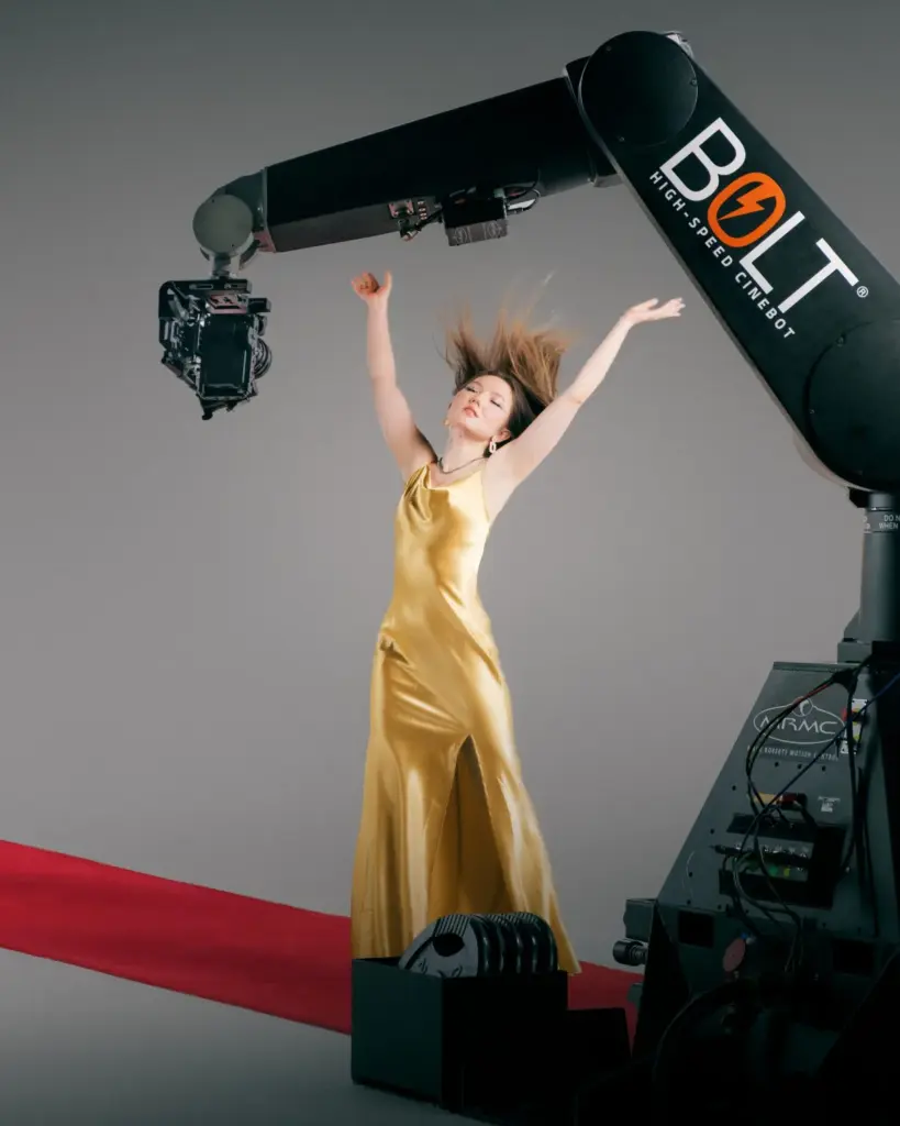 GLAMBOT Bolt Kameraroboter filmt einen Gast im goldenen Kleid auf dem roten Teppich